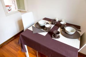 a table with a purple table cloth and bowls on it at APPARTAMENTO GALLO in Brescia