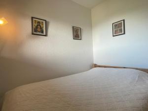 una camera con un letto e tre immagini sul muro di Appartement Méribel, 2 pièces, 4 personnes - FR-1-411-654 a Les Allues