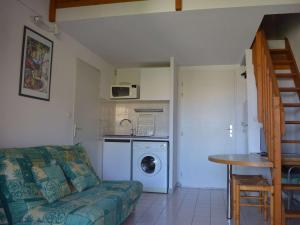 a living room with a couch and a kitchen at Appartement Cavalaire-sur-Mer, 9 pièces, 6 personnes - FR-1-226B-40 in Cavalaire-sur-Mer