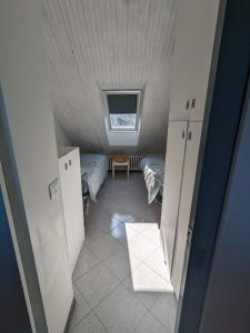 mały pokój z 2 łóżkami i oknem w obiekcie Casa 2112 w mieście Sestola