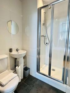 a bathroom with a shower and a toilet and a sink at Bright and Spacious 2 bed apt - sleeps up to 6 in Manchester