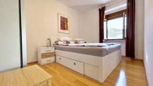 a bedroom with a bed with a dresser and a window at Apartments Gorisek in Šilo