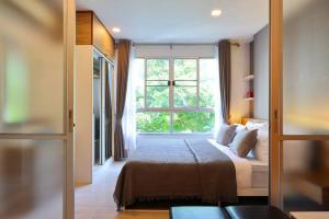 a bedroom with a bed and a large window at Greenery living in resort condo in Chiang Mai +44 photos