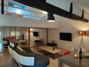 Una sala de estar con un sofá y sillas y un televisor. en Charme de Victor ConciergerieDameCarcas, en Carcassonne