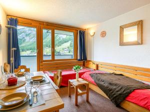 a bedroom with a bed and a table and a window at Studio Val-d'Isère, 1 pièce, 4 personnes - FR-1-694-209 in Val-d'Isère