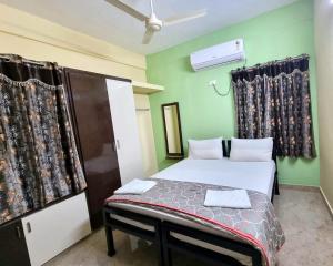 1 dormitorio pequeño con cama y cortinas en Sannidhi Service Apartments, en Tirupati