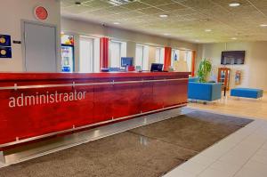 un vestíbulo de oficina con recepción roja en Tamme staadioni hostel, en Tartu