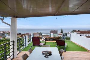 a balcony with a table and chairs and the ocean at Alojamento Lagoa in Lagoa