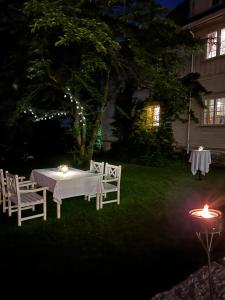 a white table and chairs in a yard at night at Øvre Sem Gård in Asker