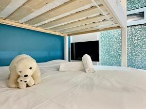 a white teddy bear sitting on a bed at Charmant appartement de 30m² avec balcon, au pied des pistes, pour 4 personnes - FR-1-411-874 in Tignes