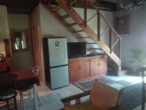 eine Küche mit einem Kühlschrank und einer Treppe in der Unterkunft Emerald Hill Cottage in Mount Pleasant