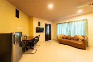 ein Wohnzimmer mit einem Sofa und einem Tisch in der Unterkunft Seasons Suites - Koramangala in Bangalore