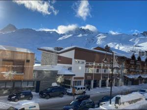 a hotel with snow covered mountains in the background at Charmant appartement de 30m² avec balcon, au pied des pistes, pour 4 personnes - FR-1-411-874 in Tignes