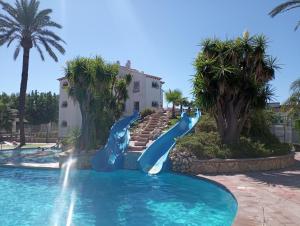 a slide in a swimming pool at a resort at Alojamiento con Piscina y chiringuito Denia in Denia