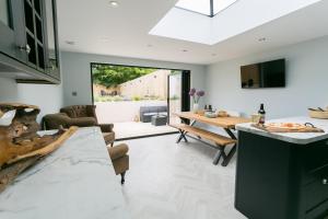 a kitchen and living room with a table and a dining room at Cae Coch in Newborough