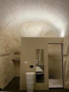 a bathroom with a white toilet in a cave at Marsili Suite in Matera