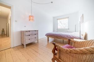 1 dormitorio con cama, silla y vestidor en Private Rooms, en Hannover