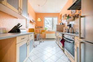 cocina con paredes de color naranja y suelo de baldosa blanca en Private Rooms, en Hannover