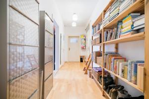 un pasillo con estanterías de madera llenas de libros en Private Rooms, en Hannover