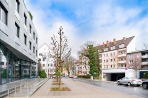 un árbol en medio de una calle con edificios en Private Rooms, en Hannover