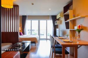 a hotel room with a bed and a table and a bedroom at Luxury Living in heart of Nimman in Chiang Mai