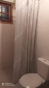 a bathroom with a toilet and a shower curtain at Casa Europeia em Cunha in Cunha