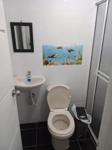 a bathroom with a toilet and a sink and a painting at La casa de los viajeros Jazmin in San Gil +26 photos