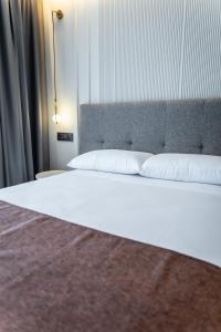 un letto con due cuscini bianchi sopra di HOTEL CORONA DE PADRÓN a Padrón
