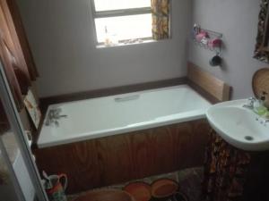 a bathroom with a bath tub and a sink at Emerald Hill Cottage in Mount Pleasant +14 photos