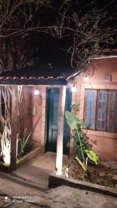 Cette petite maison dispose d'une porte bleue et d'une terrasse couverte. dans l'établissement SUÍTE VISTA LINDA, à Cunha