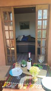 Habitación con cama y mesa con copas de vino en SUÍTE VISTA LINDA en Cunha