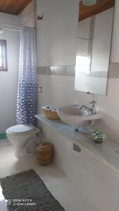 uma casa de banho com um lavatório, um WC e um espelho. em SUÍTE VISTA LINDA em Cunha