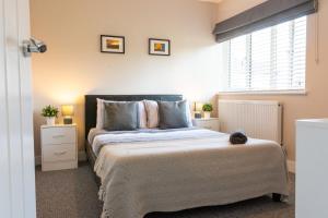 a bedroom with a large bed and a window at Stylish 4 Bed, newly renovated home in Nottingham in Nottingham