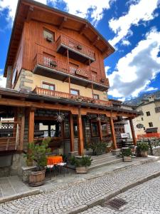 un bâtiment en bois avec des tables et des chaises devant dans l'établissement Casa di Valentina, à Breuil-Cervinia