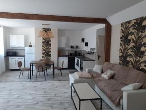 ein Wohnzimmer mit einem Sofa und einem Tisch in der Unterkunft maison en pierre avec balnéo entre Toul et nancy 