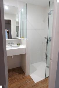 y baño blanco con lavabo y ducha. en Apartamento Palau Cadaques en Cadaqués