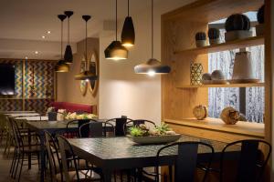 a dining room with tables and chairs and pendant lights at Catalonia Born in Barcelona