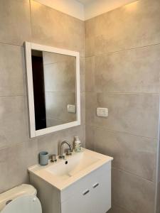 uma casa de banho com um lavatório, um espelho e um WC. em Cony Lee Esteco em Salta