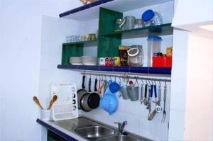 - une cuisine avec un évier et un comptoir avec des ustensiles dans l'établissement SwordFish Casa da Luz, à Peniche