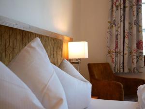 ブライトナウにあるFeriengasthof Löwenのホテルルーム(白い枕と椅子付きのベッド1台付)