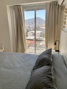 Schlafzimmer mit einem Bett und einem großen Fenster in der Unterkunft Cony Lee Esteco in Salta