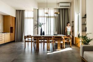 - une salle à manger avec une table, des chaises et une femme dans l'établissement Beach Villas in Crete - Alope & Ava member of Pelagaios Villas, à Ierápetra