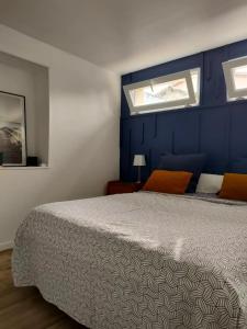 1 dormitorio con 1 cama con pared azul en Le Petit Cocon - Parking privé - Lyon Sud, en Vénissieux