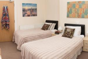 2 Betten in einem Zimmer mit weißer Bettwäsche in der Unterkunft The Bournemouth Villa by the Sea, sleeps 26 in Bournemouth