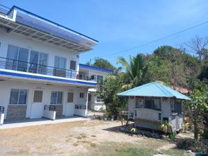 a white house with a blue roof at COSTA DE ANGELO BOLO BEACH RESORT in Alaminos