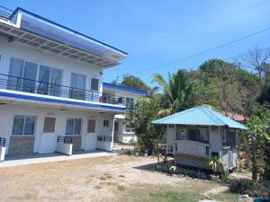 une maison blanche avec un toit bleu dans l'établissement COSTA DE ANGELO BOLO BEACH RESORT, à Alaminos