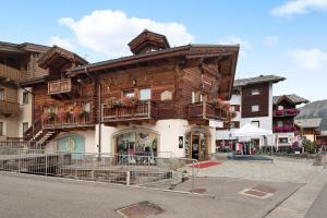 een groot houten gebouw met balkons in een straat bij Chalet Picchio Bilocale in Livigno