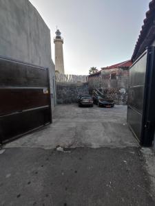 twee auto's geparkeerd op een parkeerplaats met een vuurtoren bij Sciara Biscari B&B in Catania
