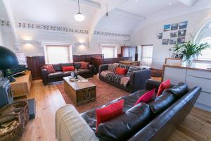 a large living room with couches and a table at Cwyfan in Aberffraw