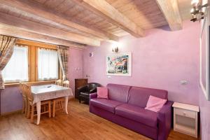 een woonkamer met een paarse bank en een tafel bij Chalet Picchio Bilocale in Livigno
